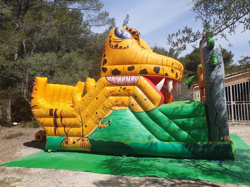 Vue latérale du toboggan dinosaure gonflable décoré pour les enfants.