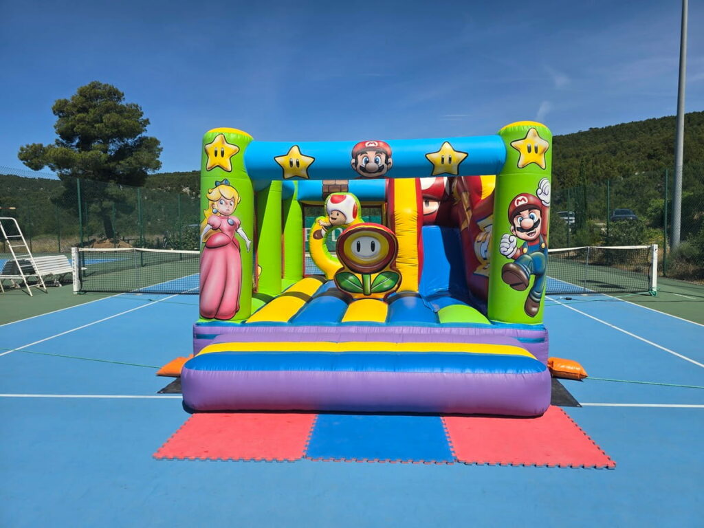 Vue frontale du château gonflable Super Mario avec décor de jeu vidéo et personnages.