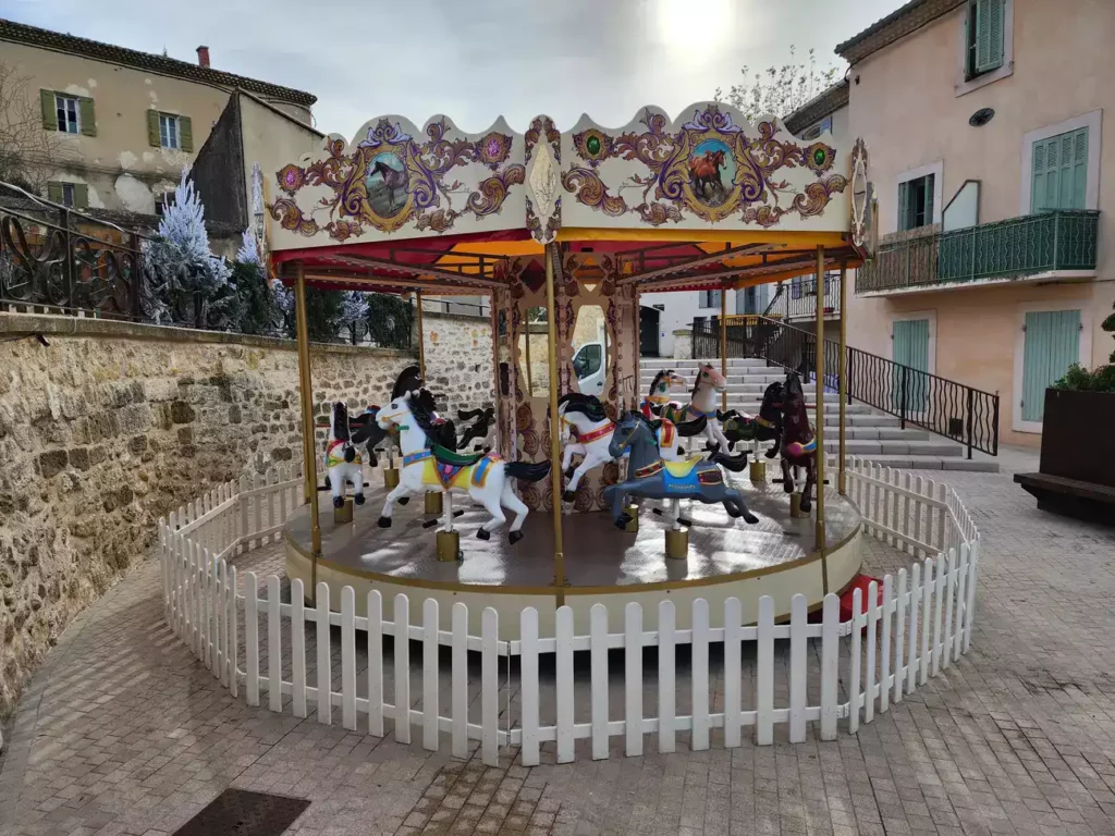 Vue frontale du carrousel ancien avec chevaux de bois peints.