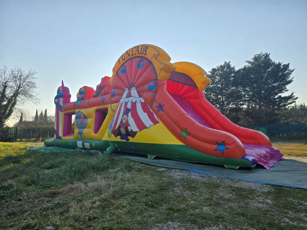 Vue partielle en angle du parcours Fun Fair avec grand toboggan gonflable.