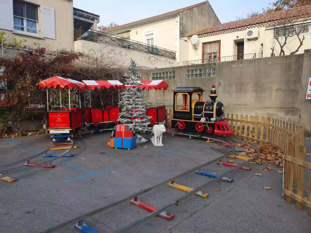 Petit train miniature avec décor forêt blanche et loup au centre.