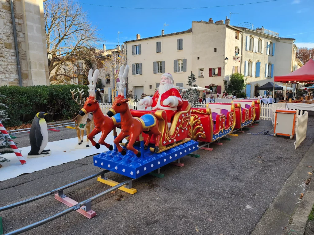 Vue frontale du manège traîneau de Noël sur rails, décor de fête.
