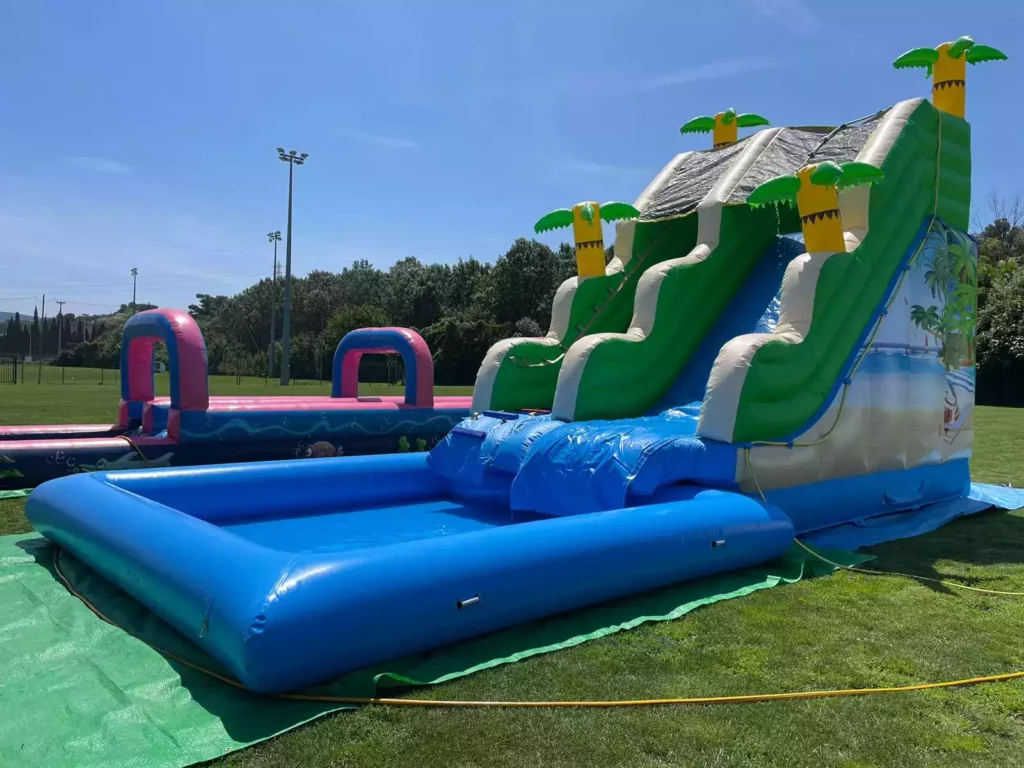 Zoom sur le toboggan Palm Beach avec détails colorés et palmiers décoratifs.