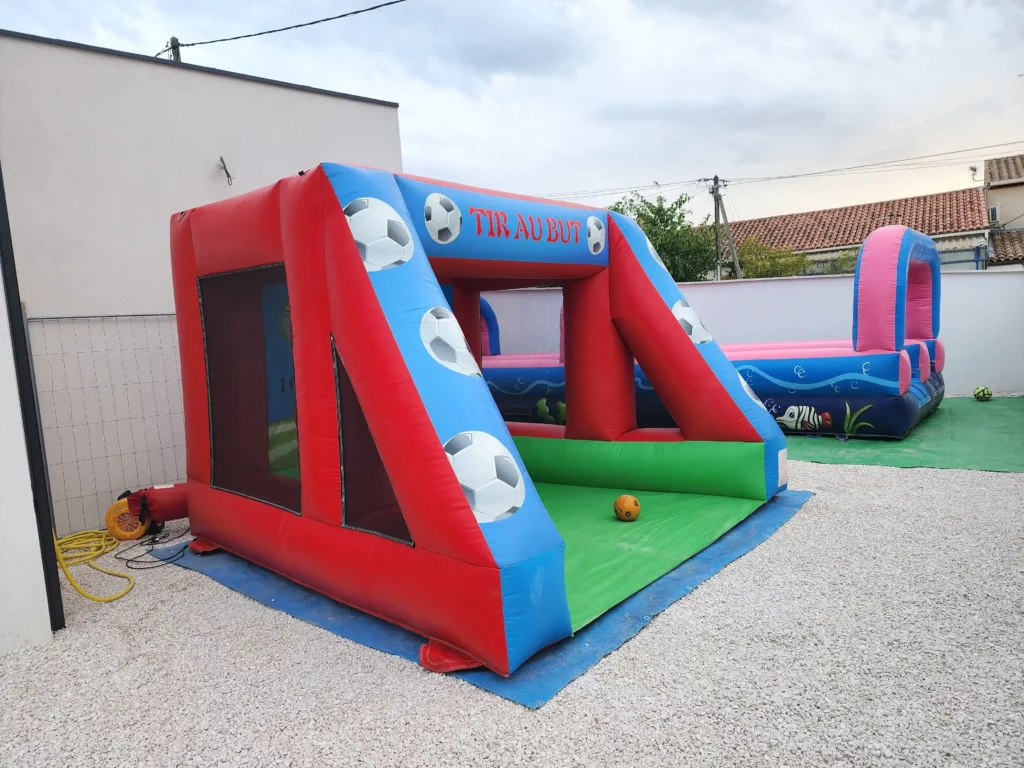 Structure de tir au but gonflable vue en 3/4, décor ballon et filets.