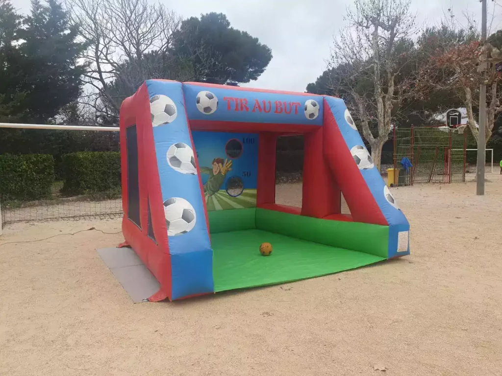 Tir au but gonflable installé sur terrain de boule en extérieur.