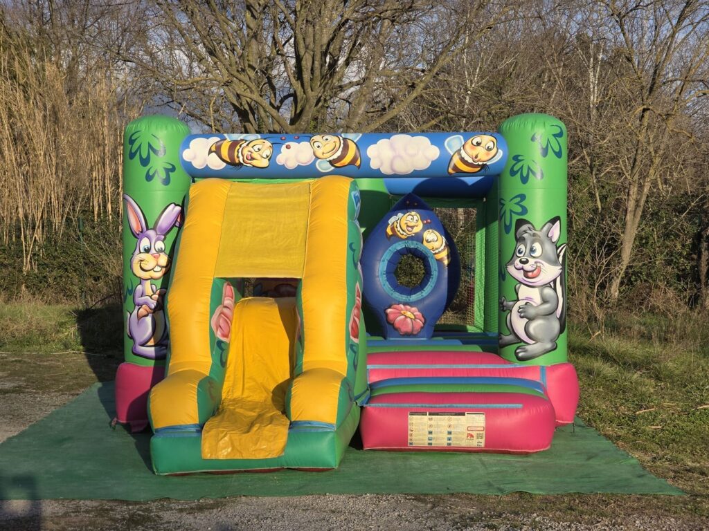 Vue frontale du château gonflable la fôret avec décor des animaux.