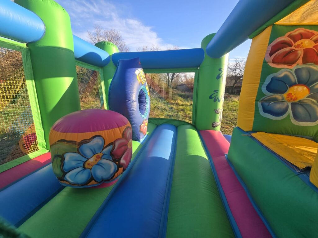 Intérieur du château gonflable combo la fôret avec obstacles et décorations de fleurs.